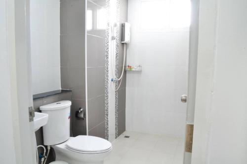 a white bathroom with a toilet and a shower at Zada Residence in Nakhon Ratchasima