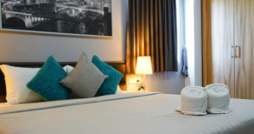 a hotel room with a bed with towels on it at Zada Residence in Nakhon Ratchasima