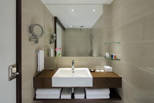 a bathroom with a white sink and a mirror at Radisson Hotel Brunei Darussalam in Bandar Seri Begawan