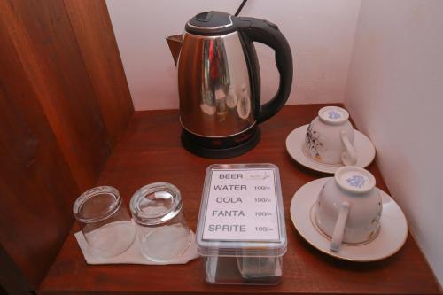a tea kettle and cups on a wooden table at The Chillout Ella in Ella