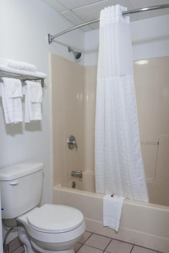 a white bathroom with a toilet and a shower at Super 8 by Wyndham Arkansas City KS in Arkansas City