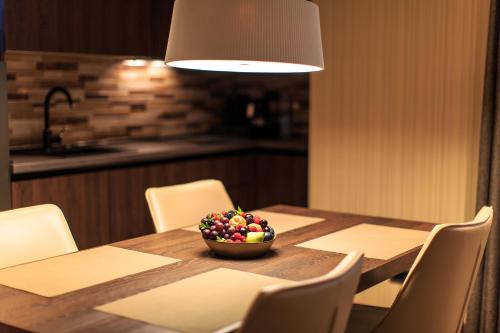 a dining room table with a bowl of fruit on it at Hotel Zeta in Budva
