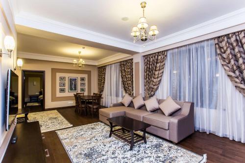 a living room with a couch and a table at Best Western Plus Atakent Park Hotel in Almaty