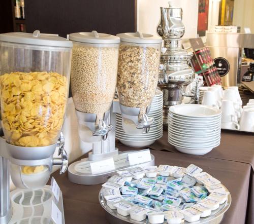 a table with four containers of food and plates at Best Western Hotel I Triangoli in Infernetto