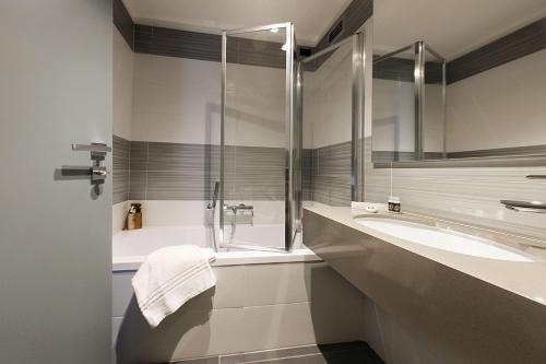 a bathroom with a glass shower and a sink at Best Western JFK Hotel in Naples