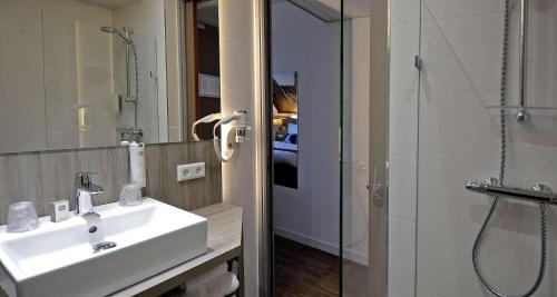 a bathroom with a sink and a shower and a mirror at Best Western City Hotel Woerden in Woerden