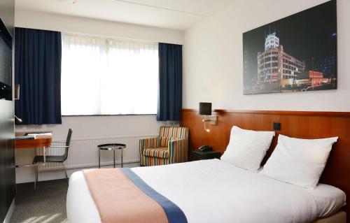 a hotel room with a bed and a desk at Amrâth Hotel Eindhoven in Eindhoven