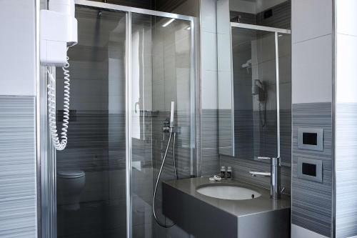 a bathroom with a sink and a glass shower at Best Western JFK Hotel in Naples