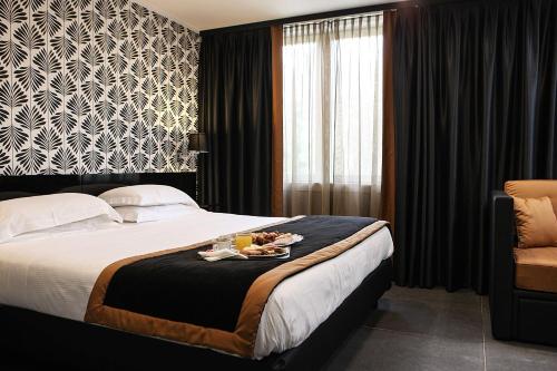 a hotel room with a bed with a tray of food on it at Best Western JFK Hotel in Naples