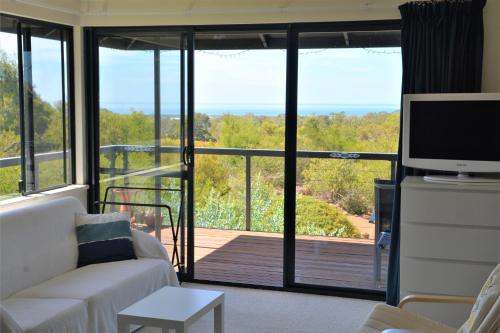 a living room with a couch and a sliding glass door at Surinam in Dunsborough