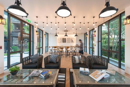 a room with a table and chairs and windows at Saturdays Residence - 1 Bedroom Service Apartment in Rawai Beach