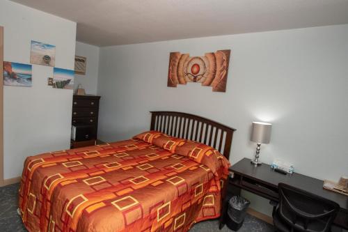 a bedroom with a bed and a desk and a bed sidx sidx sidx at Tower 64 Motel & RV in Trinidad