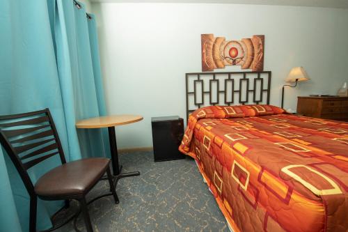 a bedroom with a bed and a table and a chair at Tower 64 Motel & RV in Trinidad