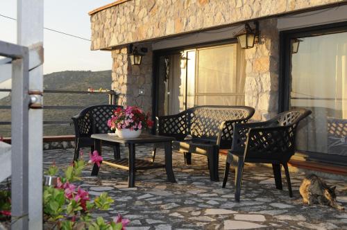 eine Terrasse mit Stühlen und einem Tisch mit Blumen darauf in der Unterkunft B&B La Vecchia Scuola in Sonnino