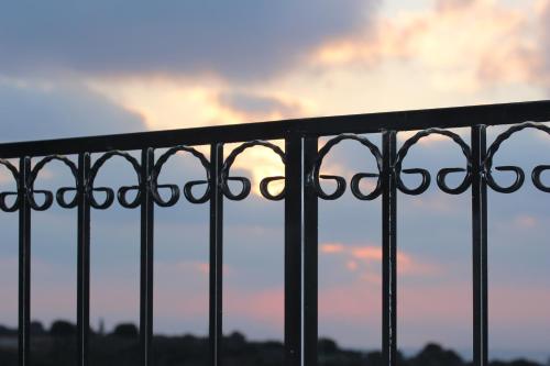 a metal fence with a sunset in the background at Benichuta in Mitzpe Hila