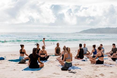 a group of people sitting on the beach at Wake Up! Byron Bay in Byron Bay