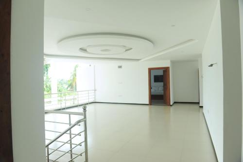 a white room with a staircase and a ceiling at Sunstar Nilaveli in Trincomalee