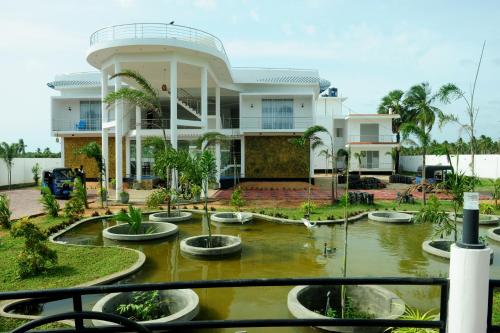 a house with a pond in front of it at Sunstar Nilaveli in Trincomalee
