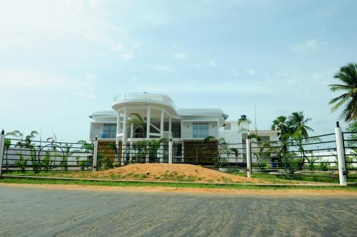 a house on a pile of dirt in front of a fence at Sunstar Nilaveli in Trincomalee