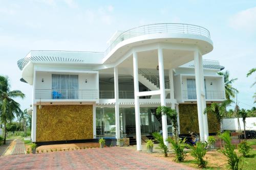 a large white building with a round porch at Sunstar Nilaveli in Trincomalee