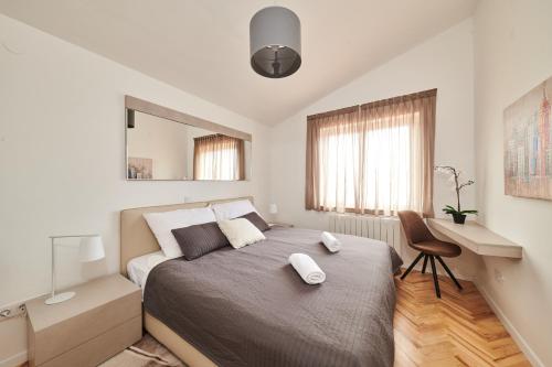 a bedroom with a large bed and a chair at Ribarska Koliba - Villa Marija in Pula