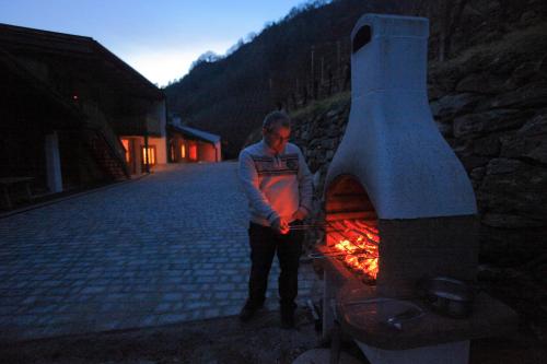 a man standing next to a fire oven at Hofer Hof in Feldthurns
