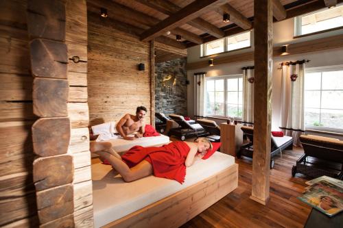 a man and a woman laying on beds in a room at Waidringer Hof 4 Sterne Superior in Waidring