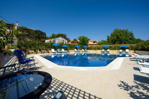 a large swimming pool with chairs and umbrellas at Angelo Del'Arte Estate in Corfu Town