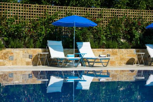 a group of chairs and an umbrella next to a pool at Angelo Del'Arte Estate in Corfu Town