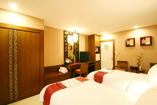 a hotel room with two beds and a desk at Mariya Boutique Hotel At Suvarnabhumi Airport in Lat Krabang