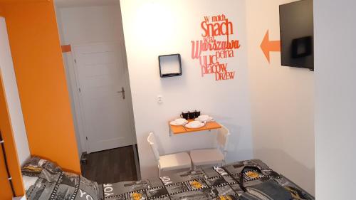 a room with a bed and a table with a chair at Walk distance to mokotow business park in Warsaw