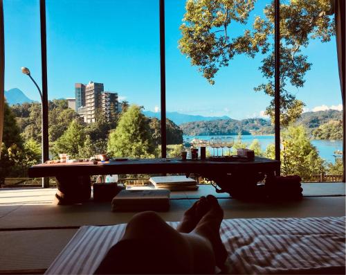 a person laying on a bed in a room with a table at Yue Lake Backpackers in Yuchi