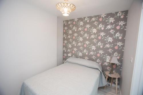 a bedroom with a bed with a floral wallpaper at Center Deluxe in Granada