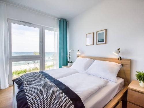 a bedroom with a bed with a view of the beach at VacationClub - Przy Plaży Apartment 10 in Mielno