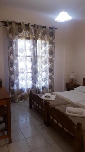 a bedroom with a bed and a window with curtains at Arianna in Paleokastritsa