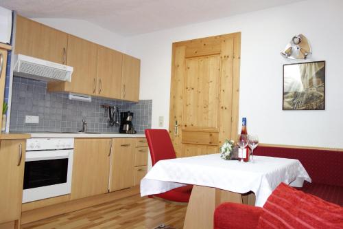 a kitchen with a table with a white tablecloth on it at Ferienhaus Inge in Sankt Leonhard im Pitztal