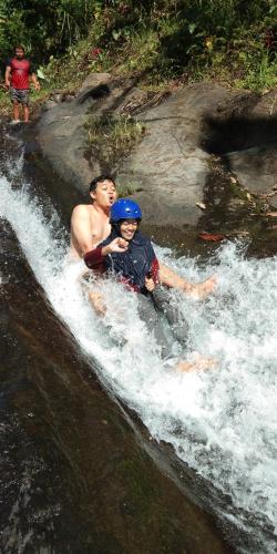 a man and a child are in a river at ESA di Kubu Homestay in Singaraja