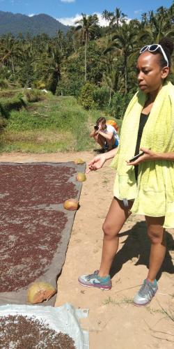 a woman in a yellow dress standing on the beach at ESA di Kubu Homestay in Singaraja