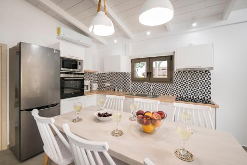 a kitchen with a table with a bowl of fruit on it at Sea View White Villa in Stavros