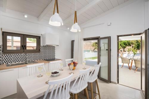 a kitchen and dining room with a table and chairs at Sea View White Villa in Stavros