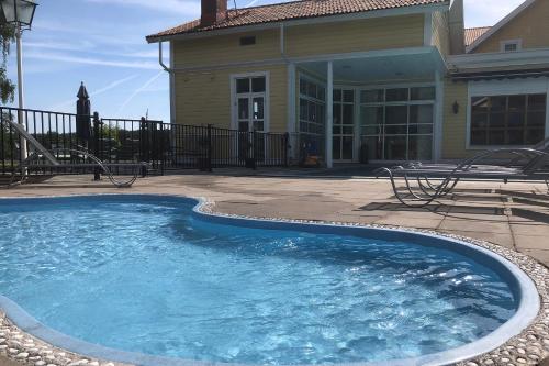a large swimming pool in front of a house at Hestraviken Hotell & Spa in Hestra