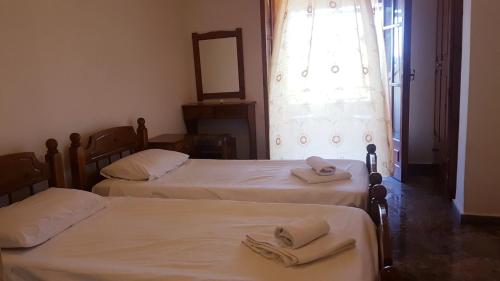 two beds in a room with towels on them at Arianna in Paleokastritsa