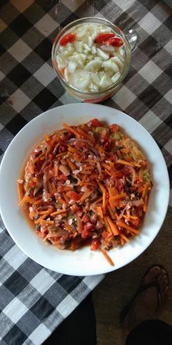 a plate of food with carrots and other vegetables at ESA di Kubu Homestay in Singaraja
