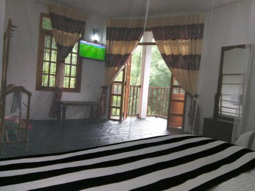 a bedroom with a bed and a balcony with windows at Rock View Rest Hatton in Hatton