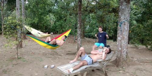 a group of people laying on hammocks in the woods at ESA di Kubu Homestay in Singaraja