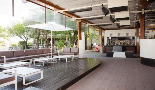 un patio con sofás y mesas y un bar en Holiday Center Valdor, en Cavallino-Treporti