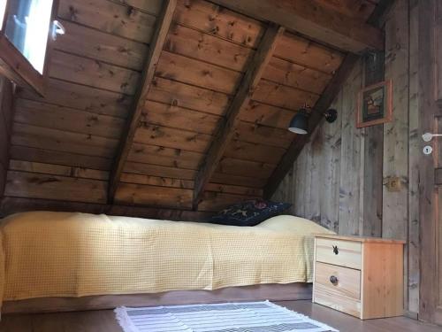 a bedroom with a bed in a wooden ceiling at Tahkuna Forest House in Kõrgessaare