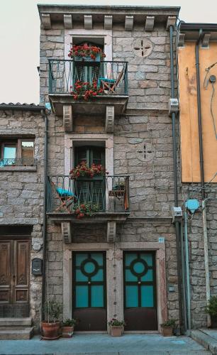 a stone building with flower boxes and windows at Lu Palazzeddu in Aggius