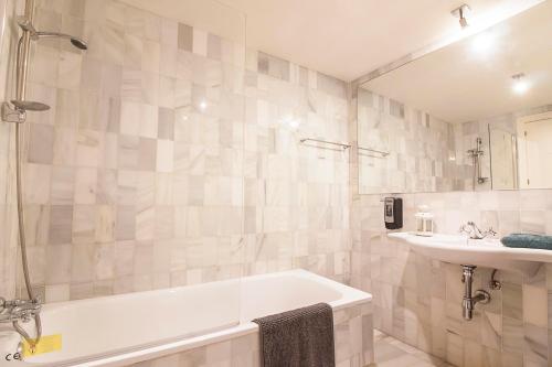 un baño con bañera y lavabo en Cortina Apartments !, en Málaga