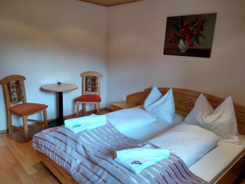 a bedroom with a bed with two chairs and a table at Gästehaus Unterberger in Zell am See